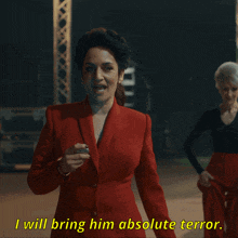 a woman in a red suit is saying i will bring him absolute terror