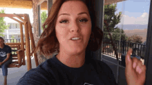 a woman wearing a blue shirt with a mountain logo on it