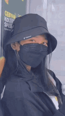 a woman wearing a bucket hat and a mask .