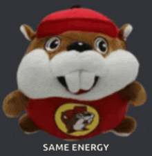 a stuffed beaver wearing a red hat and a red shirt with the word same energy on it