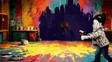 a child is standing in front of a colorful wall holding a paint brush .