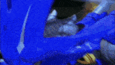 a close up of a blue robot with sharp teeth on a dark background .