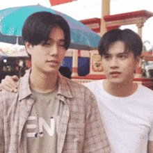 two young men are standing next to each other with one wearing a shirt that says en