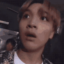 a close up of a person 's face with a shocked look on their face .