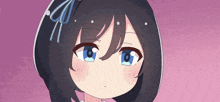 a close up of a girl 's face with a blue bow on her head