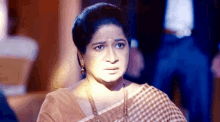 a woman in a saree is making a funny face .