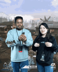 a man and a woman pose for a photo with a call of duty league background