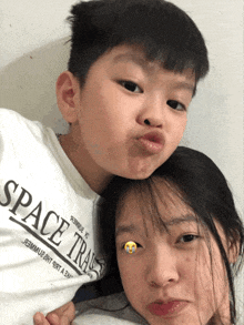 a boy and a girl are posing for a picture and the boy is wearing a shirt that says space trans