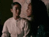 two women are sitting next to each other and one is putting her hand on the other 's shoulder