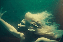a woman with blonde hair is swimming in the ocean