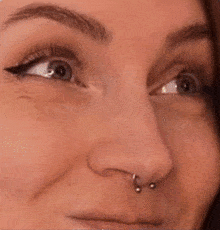 a close up of a woman 's nose with a nose ring on it