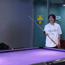 a man holding a pool cue with a shirt that says ' febercode ' on it