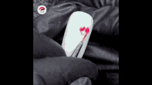 a person is painting a heart on a white nail