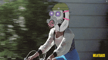 a woman wearing a gas mask is riding a bike in front of a sign that says meatbags
