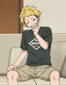 a boy is sitting on a couch wearing a black shirt that says iron cru sky-hit