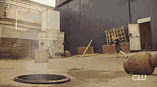a woman is jumping over a barrel in a yard .