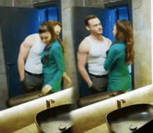 a man and a woman are looking at each other in a bathroom mirror