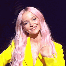 a close up of a woman with pink hair wearing a yellow jacket .