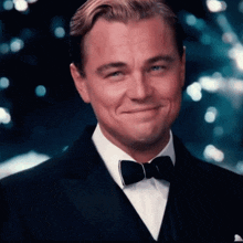 a man wearing a tuxedo and bow tie smiles