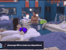 a woman standing in a bedroom with a sign that says ' descarga vix en todos tus dispositivos ' on it