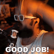 a man with a beard wearing sunglasses and ear buds says good job