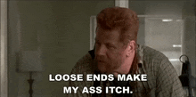 a man with red hair and a beard is talking on a cell phone while sitting in a room .