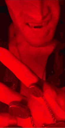 a man wearing a red shirt and a silver necklace