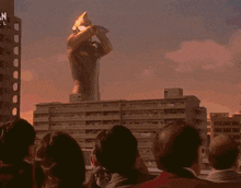 a man in a red superhero costume is flying through the air with a pink light coming out of his chest .