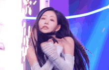 a woman with long black hair is dancing on a stage .