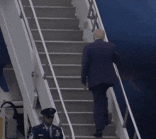 a man in a suit is walking up the stairs