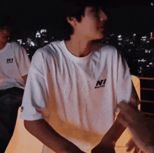a man wearing a white shirt that says ni on the front