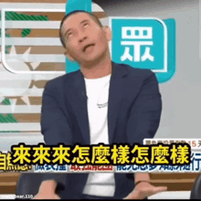 a man in a suit is making a funny face in front of a sign with chinese characters
