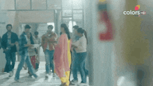 a group of people walking down a hallway with the words colors hd on the bottom right