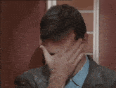 a man in a suit is clapping his hands while another man holds a hammer .