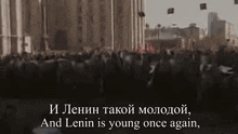 a crowd of people are gathered in front of a building with the words " and lenin is young once again " on the bottom