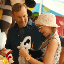 a man and a girl are looking at a stuffed animal