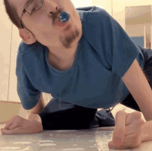 a man with glasses and a pacifier in his mouth is laying on the floor