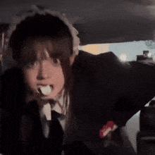 a girl in a maid costume is brushing her teeth in the back of a car
