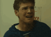 a man wearing glasses is making a funny face in front of a sign that says once