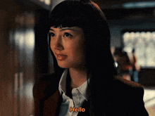 a woman with long black hair says hello in orange letters
