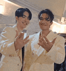 two men wearing white suits are standing next to each other