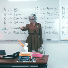 a woman stands in front of a whiteboard that says ghost girl on it
