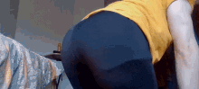 a person wearing black leggings and a yellow shirt is kneeling down