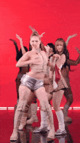 a group of women are dancing on a red background