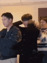 two men are standing next to each other in a room and one of them is holding the other 's head .