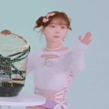 a woman is holding a bird cage in her hand .