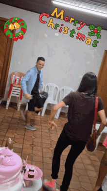 a man and a woman are dancing in a room with the words merry christmas above them