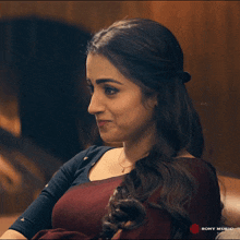 a woman sitting on a couch with a sony music logo on the bottom right