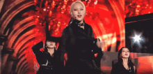 a group of women are dancing on a stage in front of a red light .