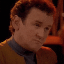 a man with red hair is making a funny face while looking at the camera .